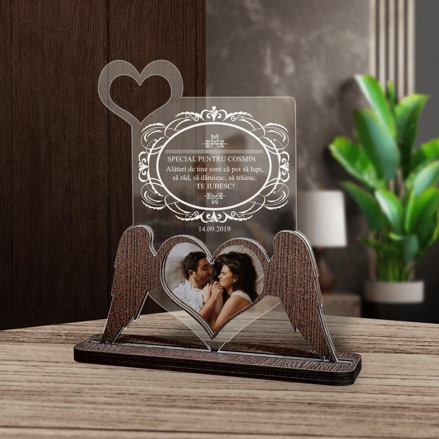 Cadou personalizat Trofeu - Aripi de iubire - Poza Trofeul 'Aripi de Iubire' este un cadou personalizat, ideal pentru a exprima dragostea și aprecierea față de persoana iubită, având o fotografie unică în formă de inimă.