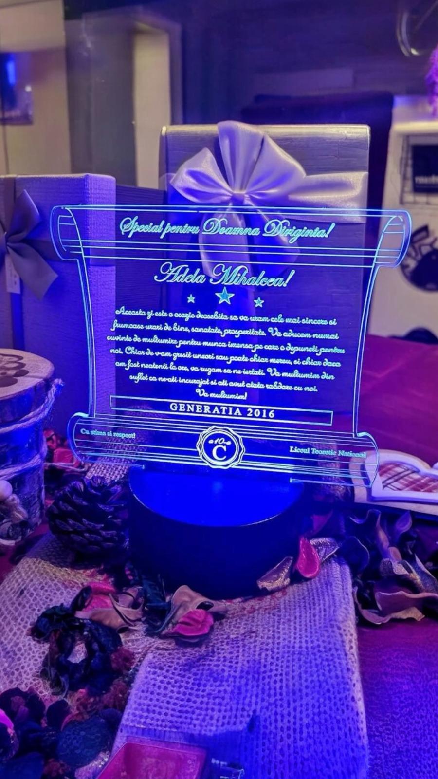 Cadou personalizat Trofeu LED - Pergament - Diriginta - Model 6 Trofeul LED pentru dirigintă este un cadou memorabil, realizat din plexiglas de calitate și iluminat pentru a evidenția mesajele personalizate.